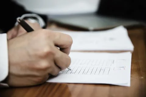 Instructor checking multiple choices answer sheet exam - education people wor Stock Photos
