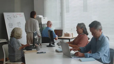 Instructor Checking Progress of Senior Computer Class Students Stock Footage 263698443