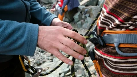 Instructor climber checks outfit on a newcomer for start Stock-Footage 135710605