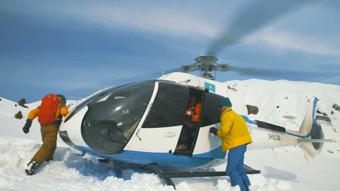 The instructor closes the helicopter door after loading skiers. Tian Shan Video stock 88602862