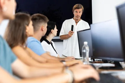 Instructor conducting software development courses to young guys and girls Stock Photos