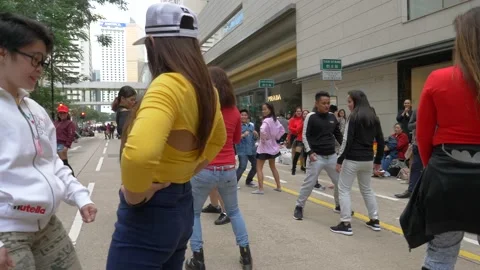 Instructor coordinating young people for a flashmob on the street in China Stock Footage 146590323