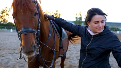 The instructor corrects the bit and invites the student sits on the horse. Stock Footage 80930491