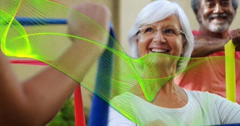 Instructor cueing seniors pulling resistance bands in fitness studio for Stockbeeldmateriaal 317859068