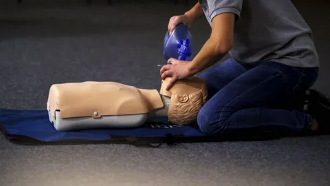 Instructor demonstrates breathing exercise on a mannequin.  Stock Footage 146747961