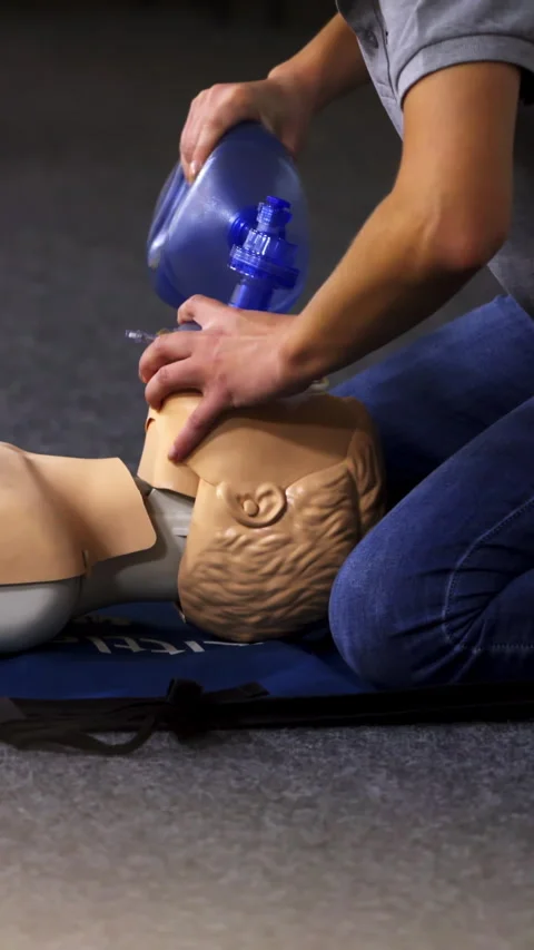 Instructor demonstrates breathing exercise on a mannequin.  Stock Footage 278587098