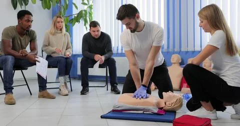 Instructor demonstrating CPR on mannequin at first aid training course. 写真素材
