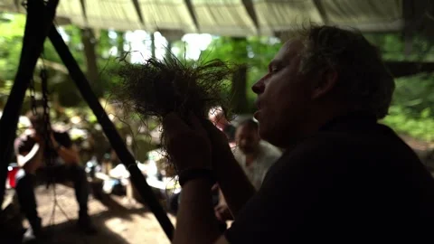 Instructor demonstrating fire starting technique using natural tinder bundle Stock Footage 330970515