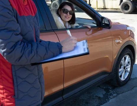Instructor in driving school is writing down results of exam Stock Photos