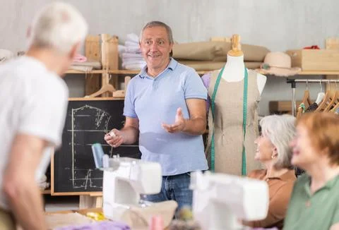 Instructor explaining garment construction at blackboard during sewing class Stock Photos