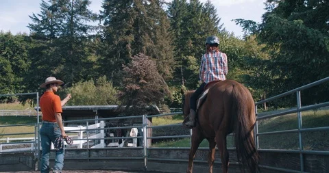 Instructor explaining riding to horseback student at equestrian lesson Stock-Footage 98319400