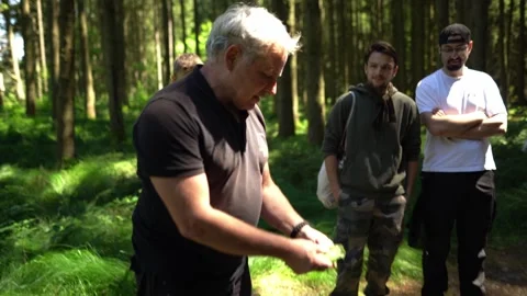 Instructor explains edible wild herbs during outdoor foraging workshop. Group Видео 331061779