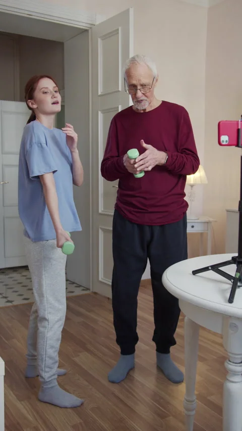 The instructor gives the elderly man dantels in his hands and they begin the Stock Footage 173572723