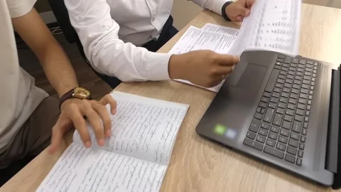 An instructor gives individual instruction to a student sitting at a table. Stock Footage 157056907