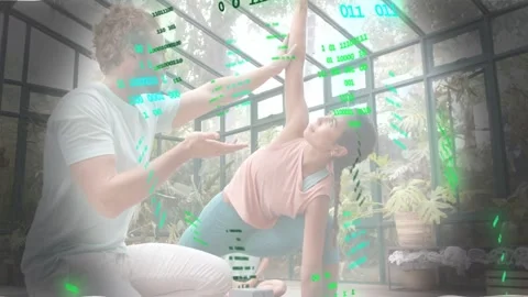 Instructor guiding student's hand, aligning yoga pose, green code overlay Stock Footage 334013756