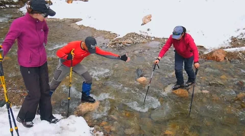 Instructor helps beginner tourist to ford the creek Stock Footage 50767325
