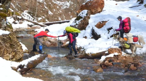 Instructor helps tourists to cross the river Stock Footage 50767828