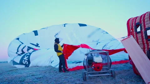 Instructor holds and inflates large hot air balloon dome Stock Footage 146685219