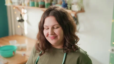 Instructor laughs during pottery class. Friendly pottery instructor with warm Stock Footage 337364481