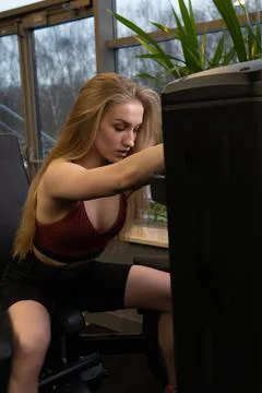 Instructor led training helps a beautiful client to perform exercises in a Stock Photos