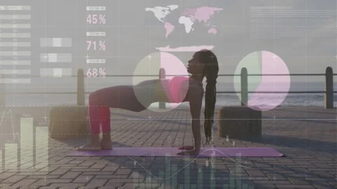 Instructor lifting hips into bridge on mat showing charts and gauges surrounding 스톡 동영상 311084870