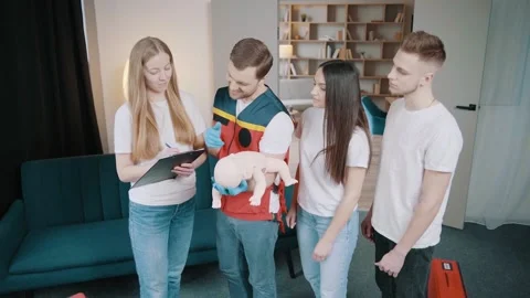 Instructor performs CPR on baby training doll Stock Footage 234430115