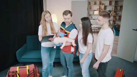 Instructor performs CPR on baby training doll Stock Footage 243179574