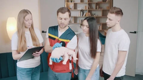 Instructor performs CPR on baby training doll Stock Footage 243179632