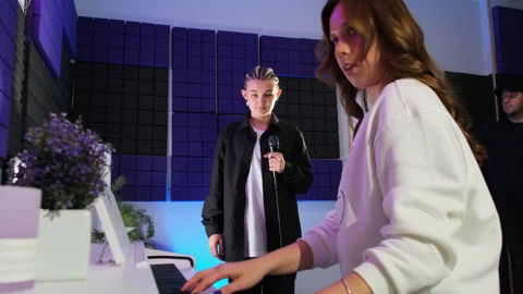 Instructor provides support with piano for young singer 스톡 동영상 307026539