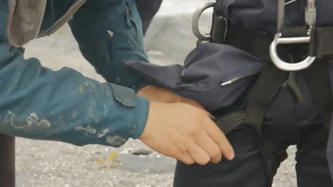 The instructor puts on special equipment for the student. Equipment for jumping Stock Footage 141790826