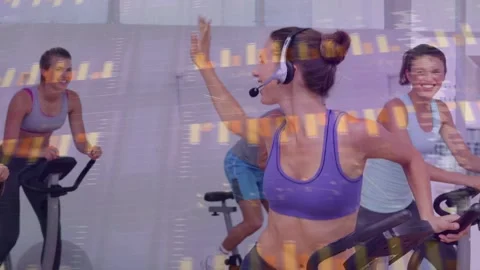 Instructor raising arm cueing class, riders riding harder boosting fitness, Stock Footage 333397127
