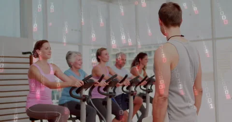 Instructor reviewing clipboard, guiding cyclists in fitness class while code Stock Footage 312844359
