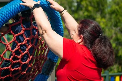 Instructor securing climbing net for children at playground Stock Photos