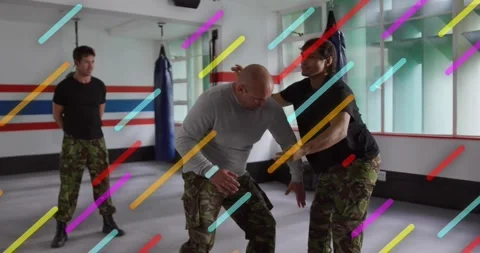 Instructor stepping behind participant applying rear lock, showing martial arts Stock Footage 320211731