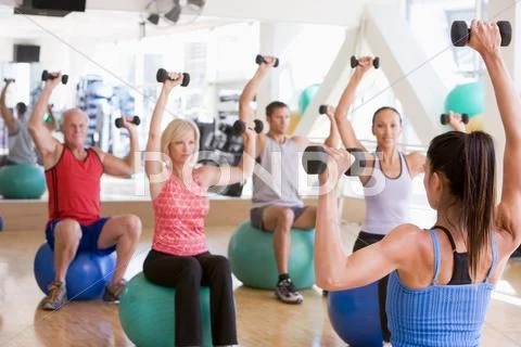 Instructor taking exercise class at gym Stock Photos