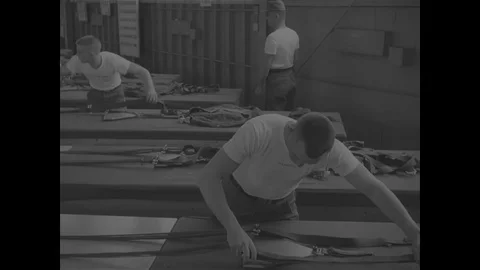 Instructor teaches how to fold the canopy of a parachute - 1967 Stock Footage 118316142