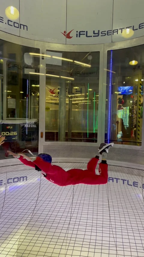 Instructor teaches man indoor skydiving. People fly in aero tube. Seattle, USA - Vidéo 208830202