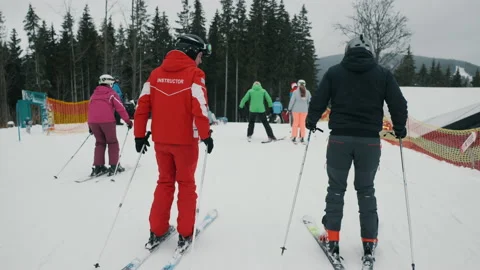Instructor teaches a man to ski in a ski resort, active rest in winter mountains Stock Footage 149179216