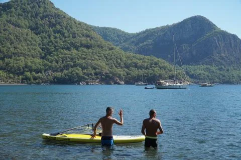 The instructor teaches the student how to windsurf. Windsurfing lessons. Stock Photos