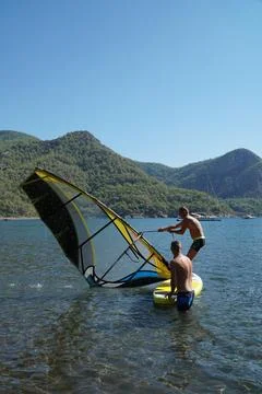 The instructor teaches the student how to windsurf. Windsurfing lessons. Stock Photos