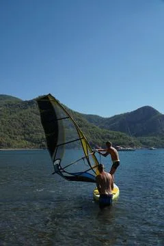 The instructor teaches the student how to windsurf. Windsurfing lessons. Stock Photos