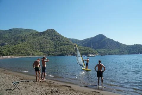 The instructor teaches students how to windsurf on the sea. Windsurfing lessons. Stock Photos