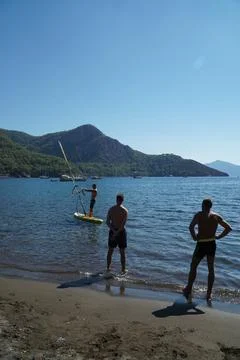 The instructor teaches students how to windsurf on the sea. Windsurfing lessons. Stock Photos