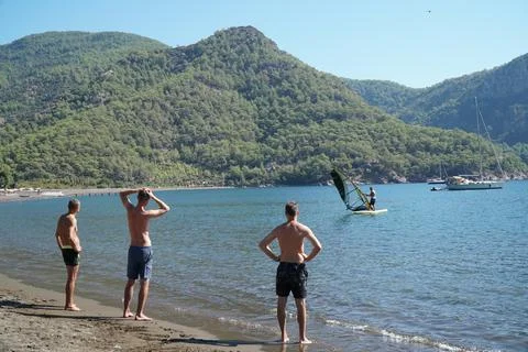 The instructor teaches students how to windsurf on the sea. Windsurfing lessons. Stock Photos
