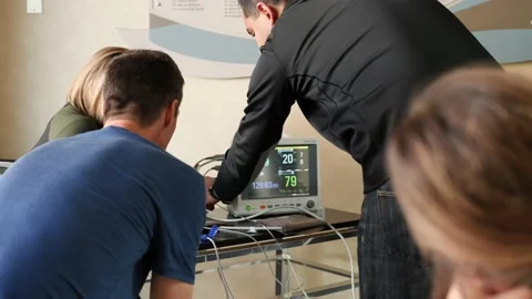 Instructor teaches trainee how to use ECG Stock Footage 142239722