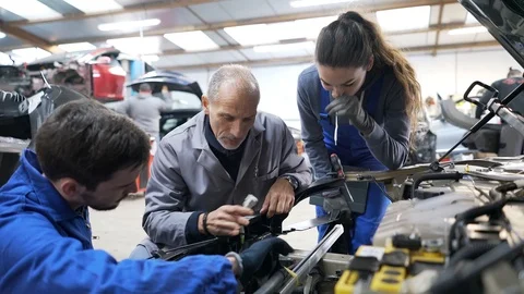 Instructor with trainees working on car engine Stock Footage 123162962