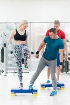 Instructor trainer showing how to do exercise with a group of people in the g Stock Photos