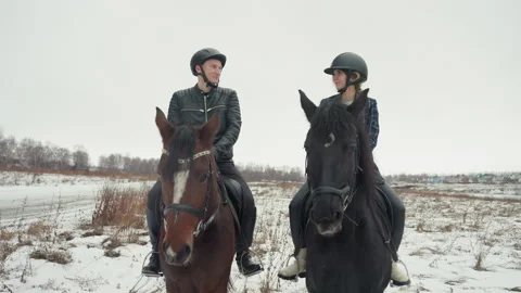 Instructors guiding students during winter horseback riding lesson. Two people Stock Footage 345176380