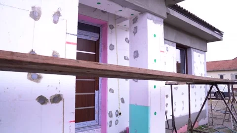 Insulation boards fixed to house exterior wall during thermal cladding Stock Footage 312444559