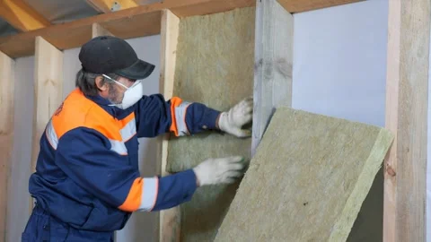 Insulation of a frame house with mineral wool. Cutting, fitting, laying 動画素材 328534657